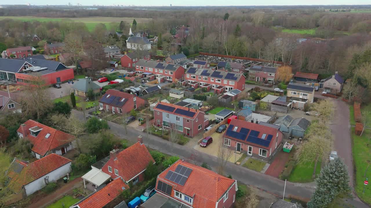 Stock droneoptagelser med fremadgående dronebevægelse over landsbyen Westerbroek i Holland. Kirken og de omkringliggende bygninger er synlige i rolige vinterdagslys omgivelser