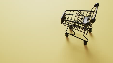 video de un carrito de compras vacío con espacio de copia en un fondo amarillo