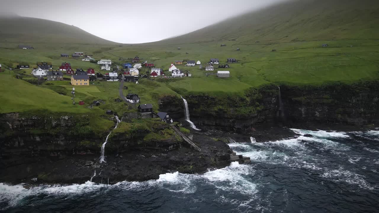 el pueblo de kalsoy ofrece vistas impresionantes con cascadas, acantilados escarpados, colinas verdes y casas coloridas. este tranquilo destino destaca la belleza intacta de las islas feroe