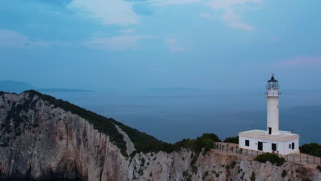 Aerial-View-Of-Doukáto-Lighthouse-On-Cliff-Edge-Of-Lefkada-Island-With-Misty-Blue-Landscape-Sea-In-Background