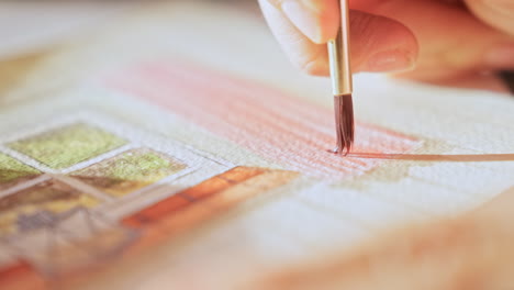 artist at work water colour painting, brush applying detail to the paper