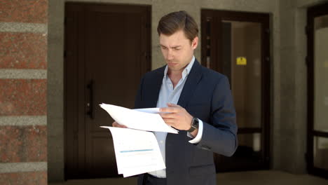 hombre de primer plano leyendo papeles de negocios. hombre estudiando documentos de negocios en la calle