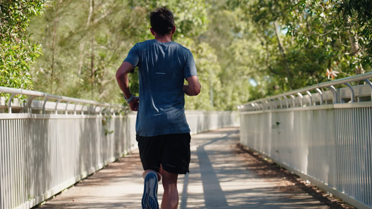 Primo piano in visuale in prima persona delle gambe e del corpo dell'atleta mentre un uomo corre attraverso il ponte, 4K Slow Motion