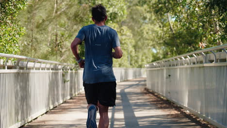 Close-Up-First-Person-View-Of-Athlete-Legs-And-Body-As-Man-Runs-Across-Bridge,-4K-Slow-Motion