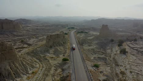 aerial following oil tanker driving along makran highway through hingol national park