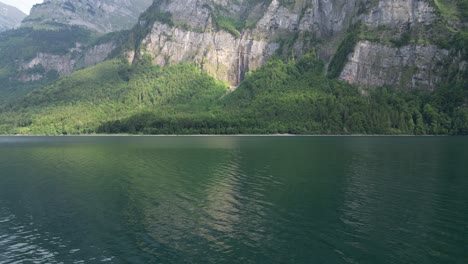 Ruhige,-Entspannende-Wellen-Erreichen-Das-Ufer-Des-Klontalersees-Mit-Felsigen-Schweizer-Alpen,-Die-Die-Ufer-Umarmen