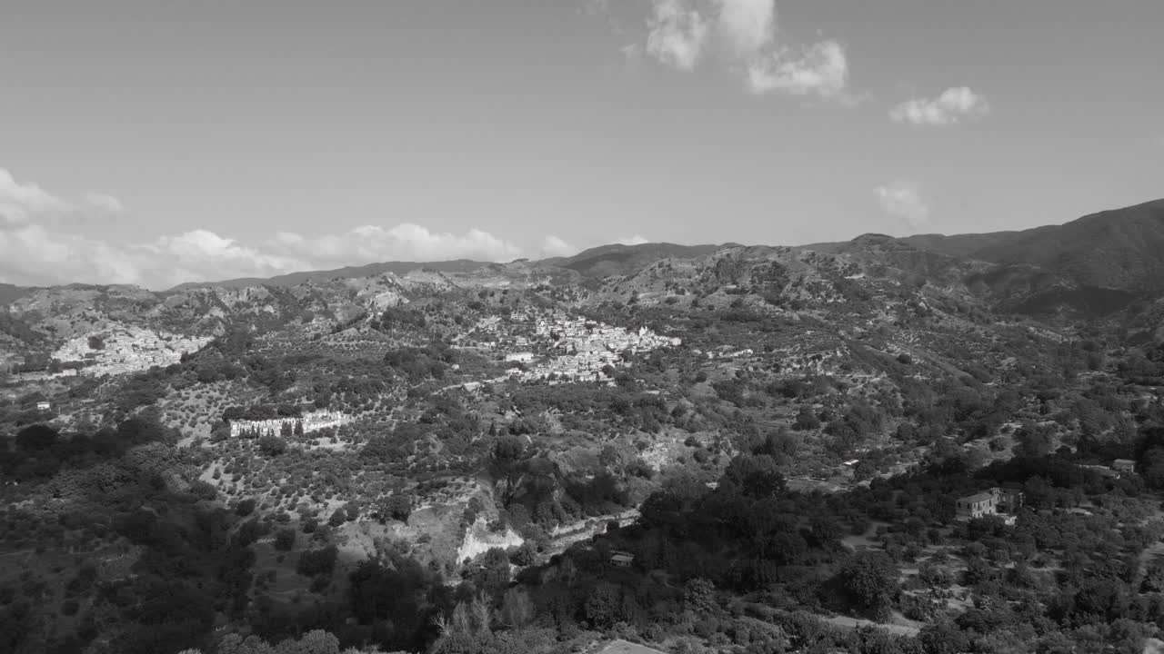 이탈리아 남부의 칼라브리아의 산과 작은 마을 위의 흑백 드론 영상.