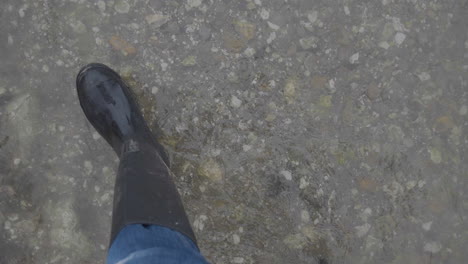 Schlammige-Stiefel,-Die-Im-Seichten-Wasser-Laufen