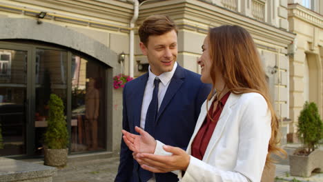 cheerful business man and woman talking together outdoors.