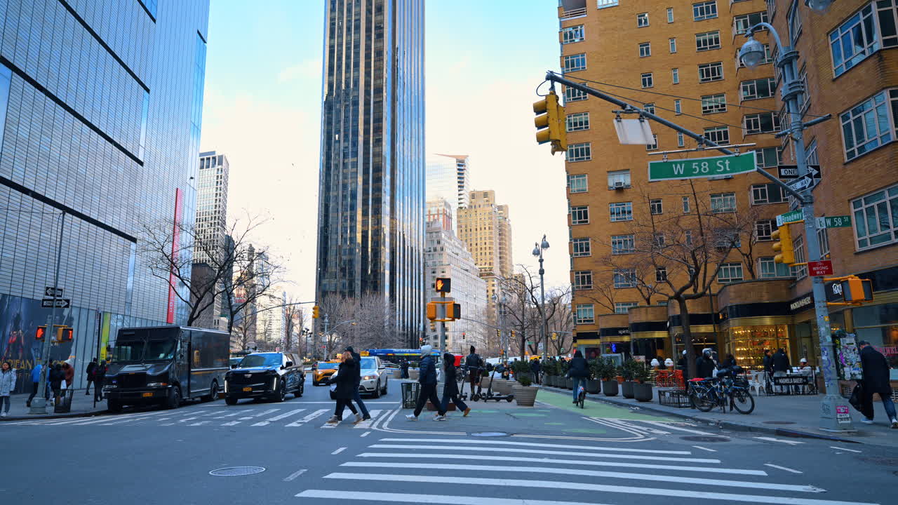 New York, USA, 2 March 2026: Street intersection at West 58th Street and Broadway NYC. Pedestrians crossing the street at an urban intersection in Midtown Manhattan surrounded by tall office buildings