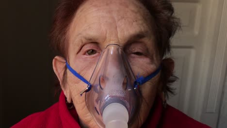 dolly out from the face of an elderly caucasian woman receiving a nebulizer treatment