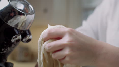 pulling pizza dough out of a stand mixer