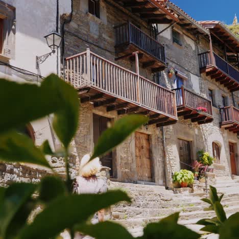 a tourist walks through the narrow streets of the village of rupit in catalonia 1