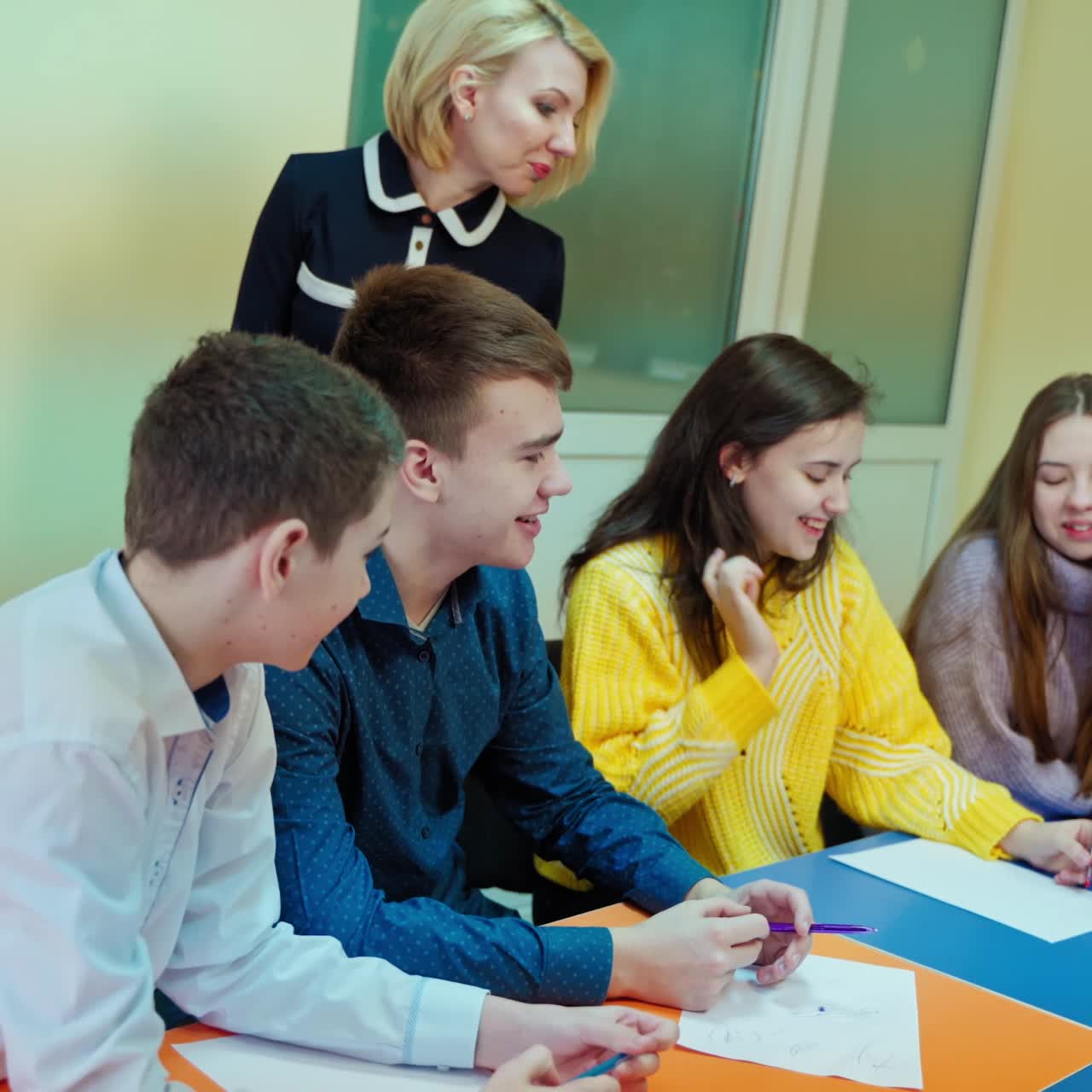 Children studying together at school. Teacher controls the study of students in the classroom. Middle school class. Back to school.