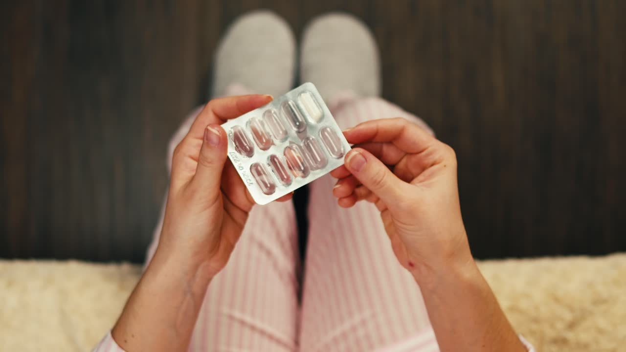 약 을 담은 블리스터 패키지 를 들고 있는 여자