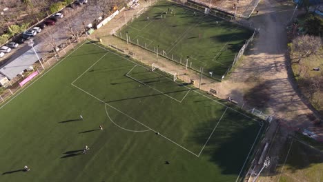 Una-Toma-Aérea-Dinámica-De-Jugadores-De-Fútbol-Entrenando-En-Dos-Campos-De-Fútbol