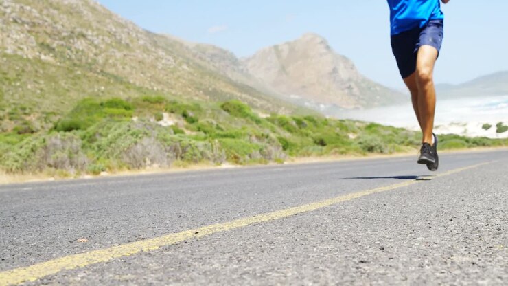 Triatleta uomo che fa jogging su una strada di campagna