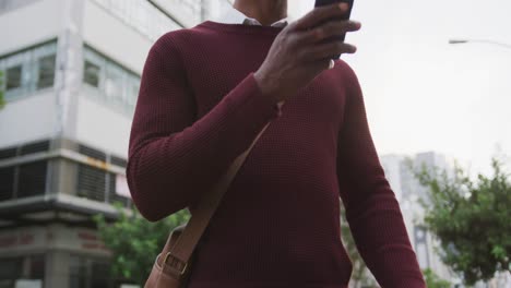 african american man using his phone in the street