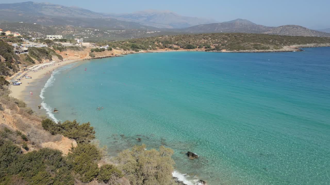 A stunning drone reveal of Voulisma Beach in Agios Nikolaos, Crete. Crystal clear waters, golden sands, and breathtaking aerial views of this iconic Greek destination