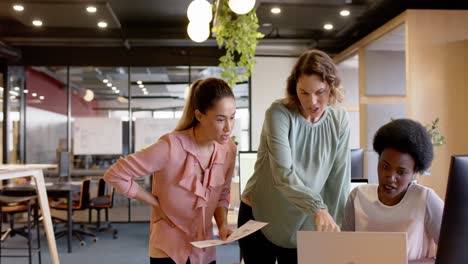 Fröhliche,-Vielfältige-Geschäftsfrauen-Diskutieren-In-Zeitlupe-über-Arbeit-Und-Nutzen-Laptop-Am-Schreibtisch-Im-Büro