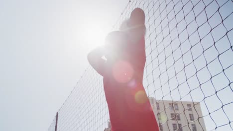 niño de fútbol afroamericano en rojo lanzando la pelota en un día soleado