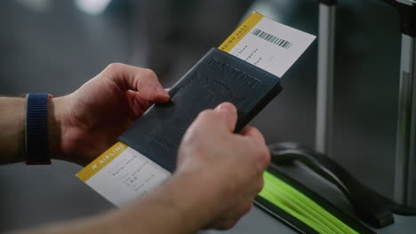 person holding passport and boarding pass at airport