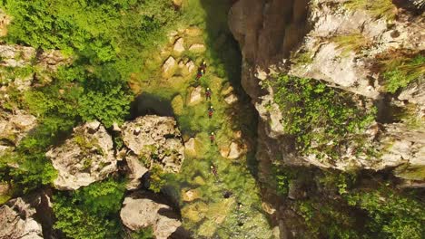 Gente-Nadando-En-El-Río,-Naturaleza-Verde-Y-Rocas