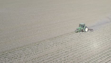 Tractor-Arando-Cultivos-De-Campo-Secos-Y-Polvorientos,-Vista-Aérea-De-Drones