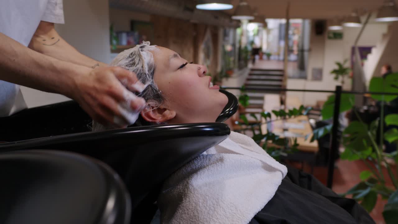 여자 가 미용실 에서 머리 를 고 있다