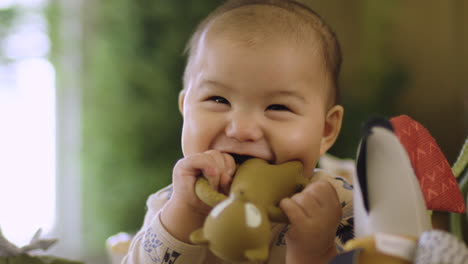 Adorable-Y-Lindo-Bebé-Asiático-Sonriendo-Y-Riendo-Mientras-Le-Salen-Los-Dientes-Y-Mastican-También