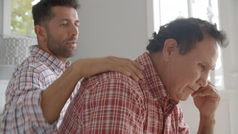 hijo adulto consolando al padre deprimido