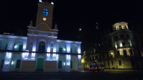 edificio público colonial español del siglo xvii en un excelente estado de conservación por la noche con luces decorativas con otros edificios prominentes