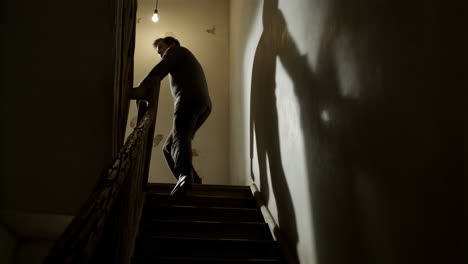 man walking up stairs in a dark building