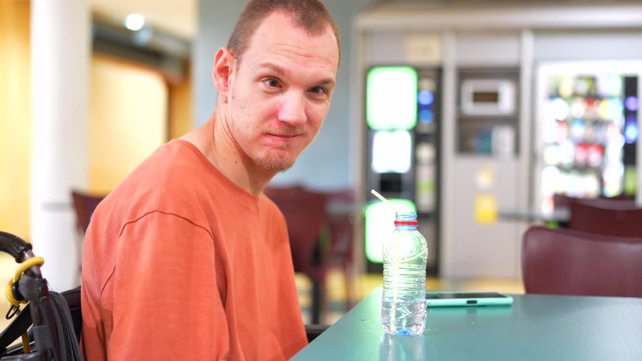 Man in Wheelchair Drinking Water