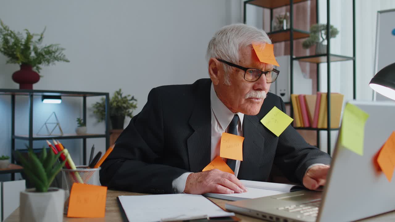 피곤하고 지친 고위 사업가 노트북을 가진 사무실 관리자 많은 작업을 하는 붙잡은 메모를 가지고 있습니다.