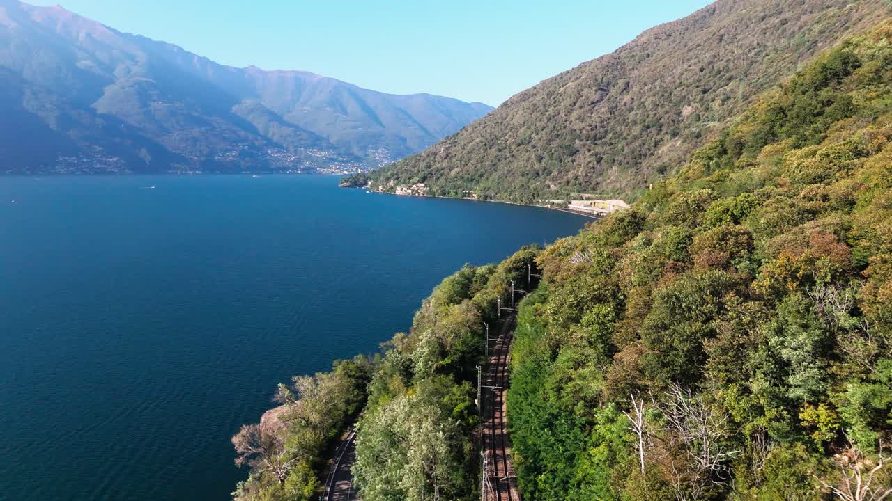 Fly along railroad next to Lake Maggiore, summer day in Italy