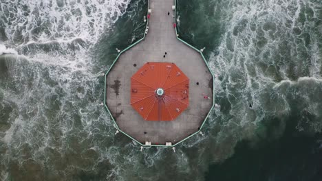 el océano pacífico se estrella alrededor del muelle de la playa de manhattan en california