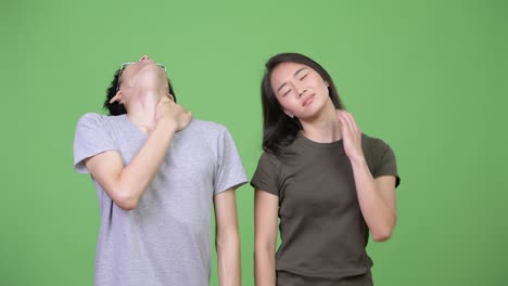 young asian couple having neck pain together