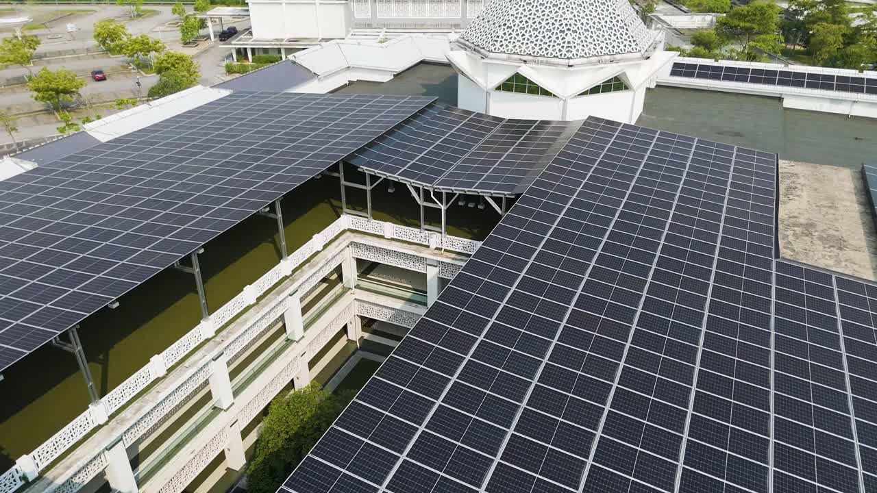 Fly over shot the Raja Haji Fi Sabililah Mosque in Cyberjaya, Malaysia, with a solar panel rooftop. Architecture and renewable energy surrounded by greenery