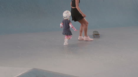 mother and child skateboarding in indoor skate park