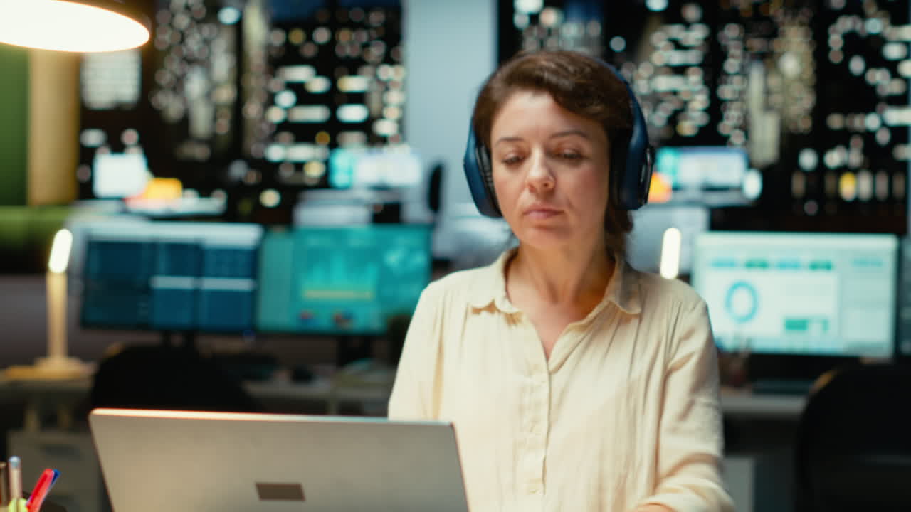 Vertical Video Businesswoman taking headphones out and stretching her back at desk