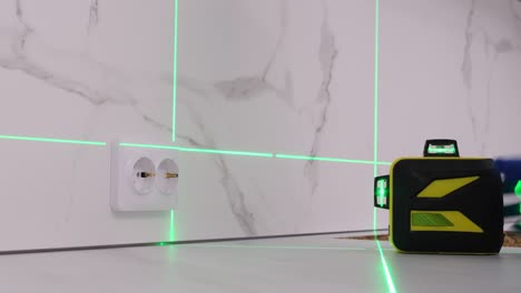 using a construction laser a man collects kitchen furniture repair in the house using a construction laser a man collects kitchen furniture repair in the house