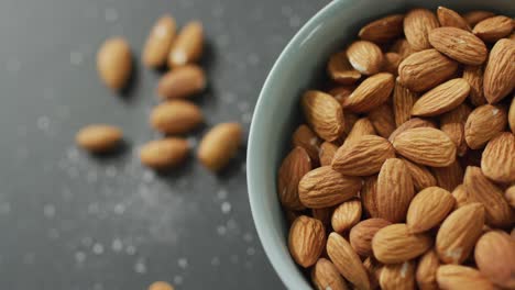 Video-of-fresh-fruit-almonds-in-a-bowl-on-grey-background