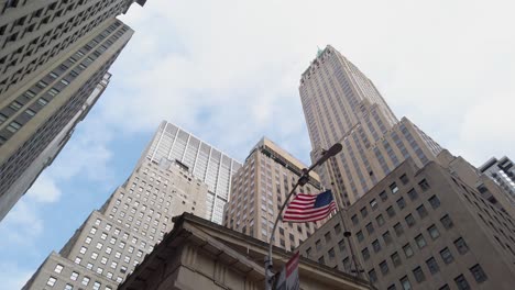 empire state building, new york. low angle view of skyscraper and american flag under summer sky