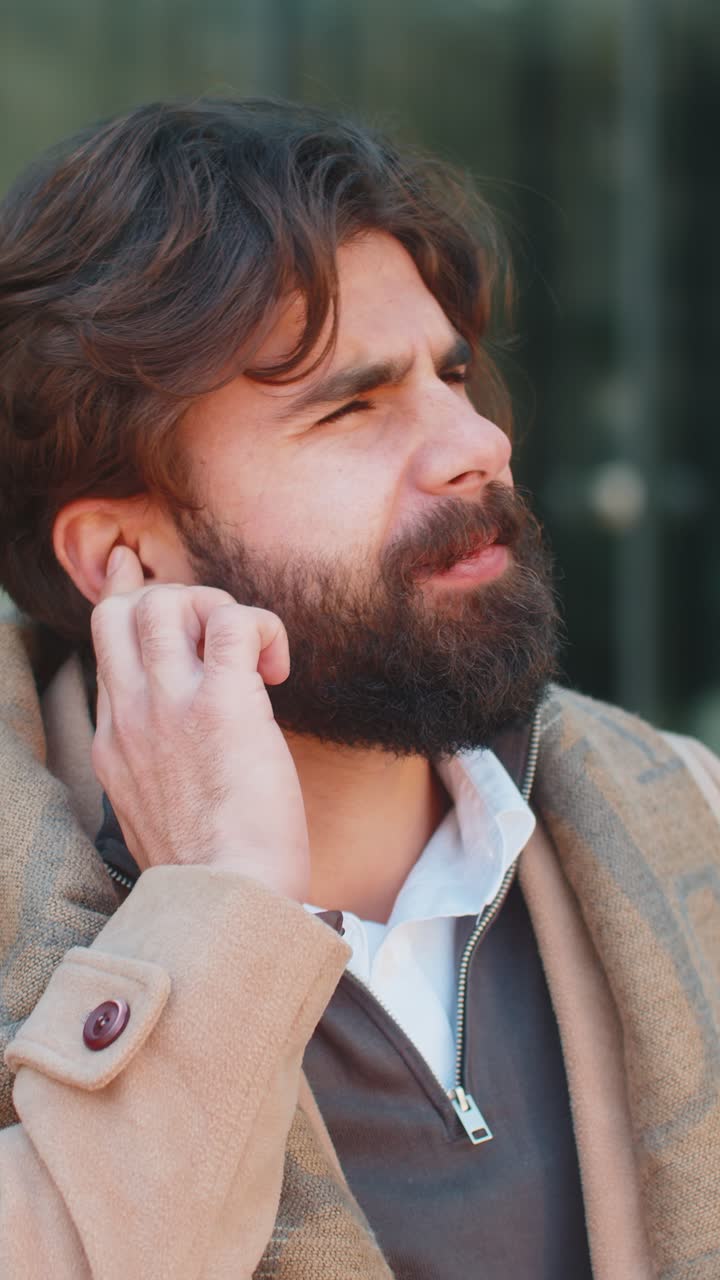 joven hombre de negocios indio sufre de dolor de oído dolor de oídos infección inflamación en la calle de la ciudad