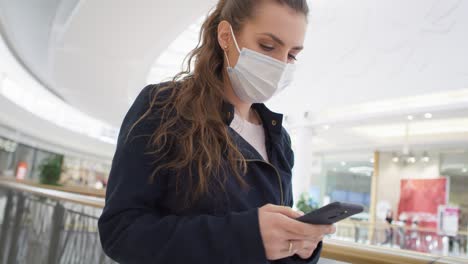 video of woman in mask using phone in shopping mall