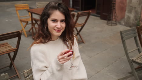 Smiling-girl-with-glass-of-red-wine-outdoors