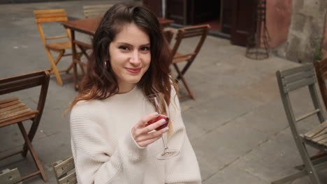 Niña-Sonriente-Con-Una-Copa-De-Vino-Tinto-Al-Aire-Libre