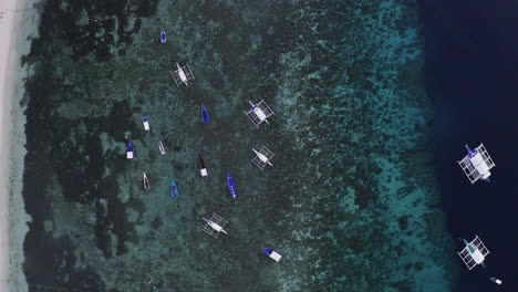 Aerial-Top-Down-shot-of-outrigger-boats-on-close-to-the-shore-in-the-Philippines,-Asia,-Drone