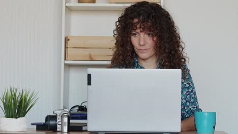 mujer trabajando en una computadora portátil desde casa
